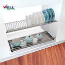 Referencing Adjustable dish rack SJ304.jpg, a polished stainless steel two-tier dish rack is installed inside a white wall cabinet, with the top slotted layer holding plates and the bottom flat layer holding light blue bowls and cups.