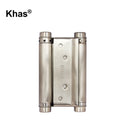 Khas double action hinge in a metallic finish, displaying its dual-cylinder spring mechanism for two-way door movement and Khas engraving.