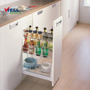 Referencing Spice rack drawer baskets for kitchen cabinet PTJ023D 1.jpg, a detailed schematic line drawing illustrates the three-tier wire basket structure and sliding track mechanism. Additionally, Spice rack drawer baskets for kitchen cabinet PTJ023D.jpg displays the gleaming chrome organizer pulled out from a white base cabinet, fully stocked with spices, vinegar, water bottles, and ceramic bowls.