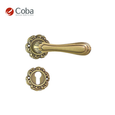 Bronces Coba 360-G Handle Set with Rosettes and Key Hole Escutcheon in Old Antique Brass Finish, made in Spain, featuring intricate vintage detailing.