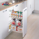 Wellmax KPTJ009G 3-layer Jolly basket side-mounted pull-out organizer in a chrome finish, installed in a white base cabinet and fully stocked with drinks, coffee, and pantry items.
