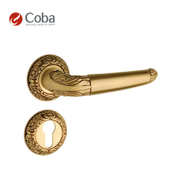 Bronces Coba 610-SG Handle Set in Old Antique Brass Finish, made in Spain, featuring an ornate design with rosettes and key hole escutcheon.