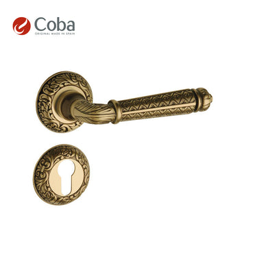 Bronces Coba 910-G Handle Set with Rosettes and Key Hole Escutcheon in Old Antique Brass Finish, made in Spain, featuring intricate craftsmanship.
