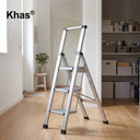 Referencing Anti-Slip Household Ladders 1.jpg, a sleek 3-step aluminum household ladder featuring black anti-slip treads and an ergonomic top handle is displayed against a plain white background. Anti-Slip Household Ladders.jpg showcases the stylish aluminum ladder deployed in a bright, modern home hallway next to an organized storage room, ready for household use.