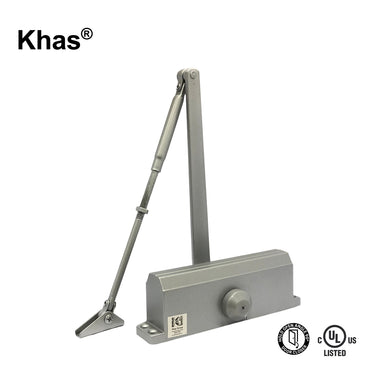Khas 643-D surface-mounted door closer in a silver finish, showing the hold-open slide arm mechanism, main body with Khas branding, and the 90-degree hold-open and C-UL-US Listed stamps.