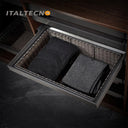 Referencing RATTAN BASKET 1.jpg, a pull-out grey rattan basket in a dark wood wardrobe holds neatly folded striped and textured dark clothing. RATTAN BASKET 2.jpg shows the empty grey PE imitation rattan basket pulled out from the closet shelf. RATTAN BASKET 3.jpg displays a graphic showing the internal mechanisms of the silent damping guide rail with orange arrows indicating smooth movement. RATTAN BASKET 4.jpg provides a close-up highlighting the frosted grey space aluminum frame edge and the woven rattan