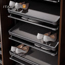 Referencing REVOLVING SHOE RACK .jpg, a split image shows the grey multi-layer rotating shoe rack installed in a dark wardrobe on the left, and being manually rotated by hands on a white background on the right. REVOLVING SHOE RACK 1.jpg displays the rack angled outward in a dark wood closet, showing high heels and flats stored on its staggered leather-lined shelves. REVOLVING SHOE RACK 2.jpg gives a slim side-profile view of the revolving rack inside the wardrobe. REVOLVING SHOE RACK 3.jpg provides a close