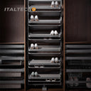 Referencing REVOLVING SHOE RACK .jpg, a split image shows the grey multi-layer rotating shoe rack installed in a dark wardrobe on the left, and being manually rotated by hands on a white background on the right. REVOLVING SHOE RACK 1.jpg displays the rack angled outward in a dark wood closet, showing high heels and flats stored on its staggered leather-lined shelves. REVOLVING SHOE RACK 2.jpg gives a slim side-profile view of the revolving rack inside the wardrobe. REVOLVING SHOE RACK 3.jpg provides a close