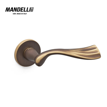 Mandelli 1201 River door handle in matte bronze, highlighting its elegant wave-like design and smooth, tactile surface, crafted from solid brass in Italy.