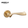 Mandelli 1201 River door handle in polished brass, showcasing a sleek, curving design with a shiny finish, crafted from solid brass in Italy.