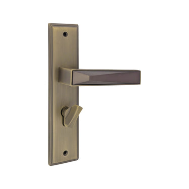 S1245H1779 door handle set on a rectangular backplate in an AB/MAB finish, featuring an angular lever with a faceted dark inlay and a privacy turn knob.
